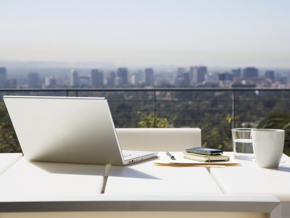 laptop na biurku na tle budynków